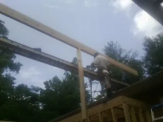 Carpenter setting a ridge beam over a new addition frame — Ice Dam Removal by Roofing Brothers in Brielle