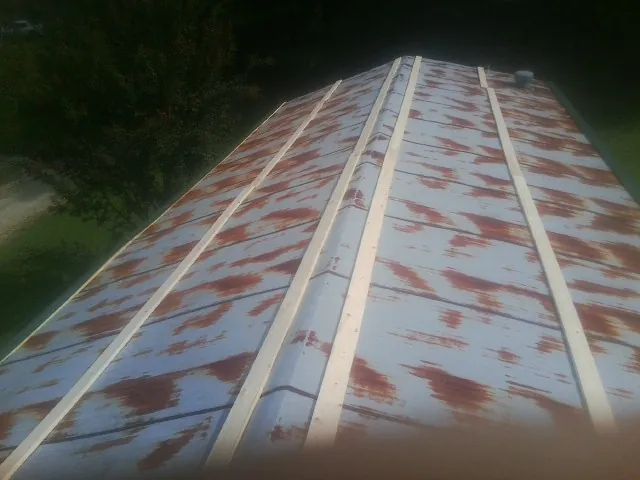 Rusted metal roof panels with new wood purlins before replacement — Storm Damage Roof Repair in Brielle by Roofing Brothers
