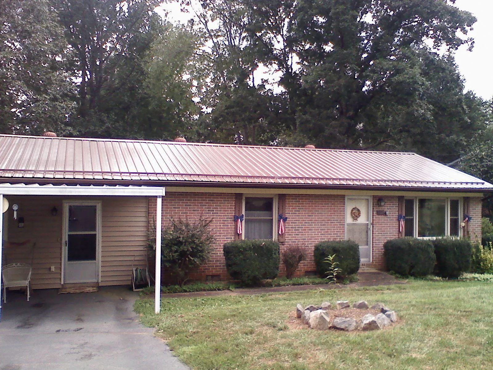 Bronze metal roof and carport on a brick ranch home — Roof Repair work by our crew in Brielle
